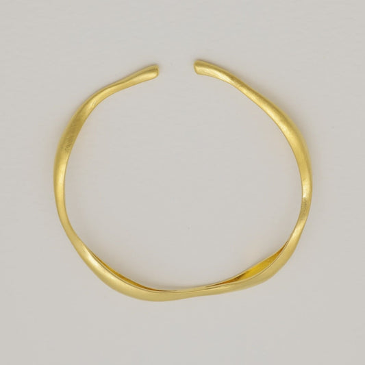 "Gold vermeil sculptural cuff bracelet on cream background"

