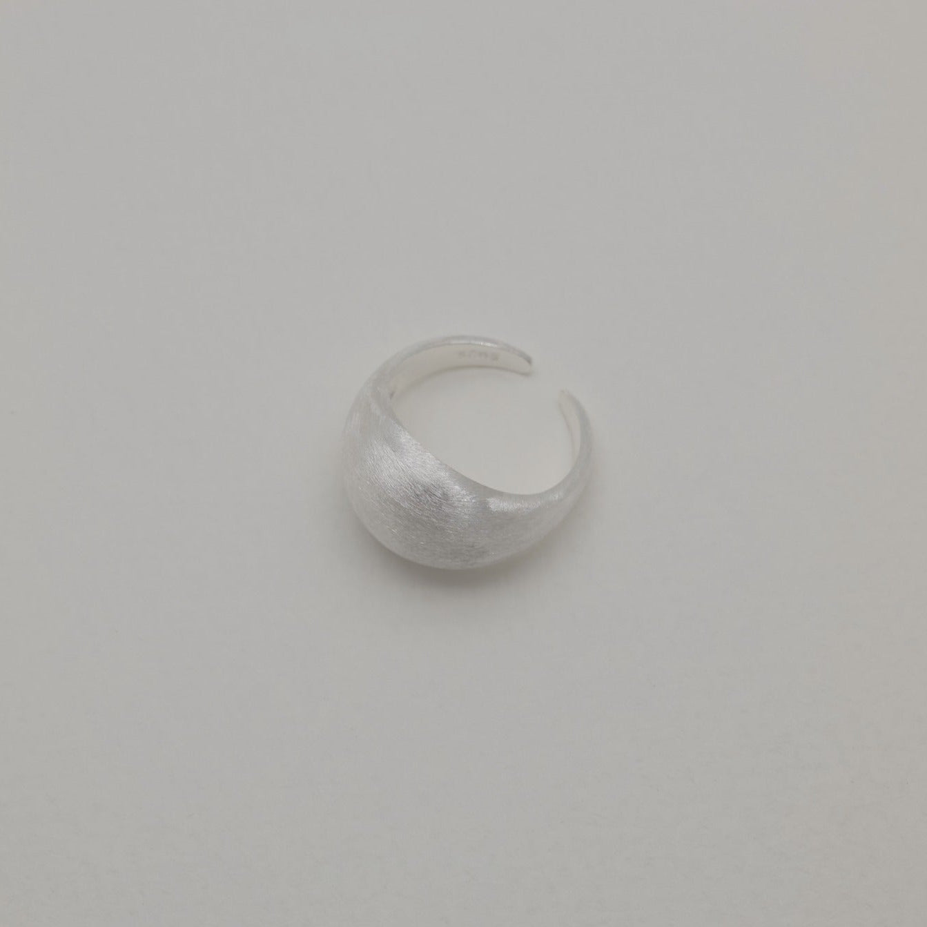 Brushed silver dome ring with soft matte finish, centered top view
