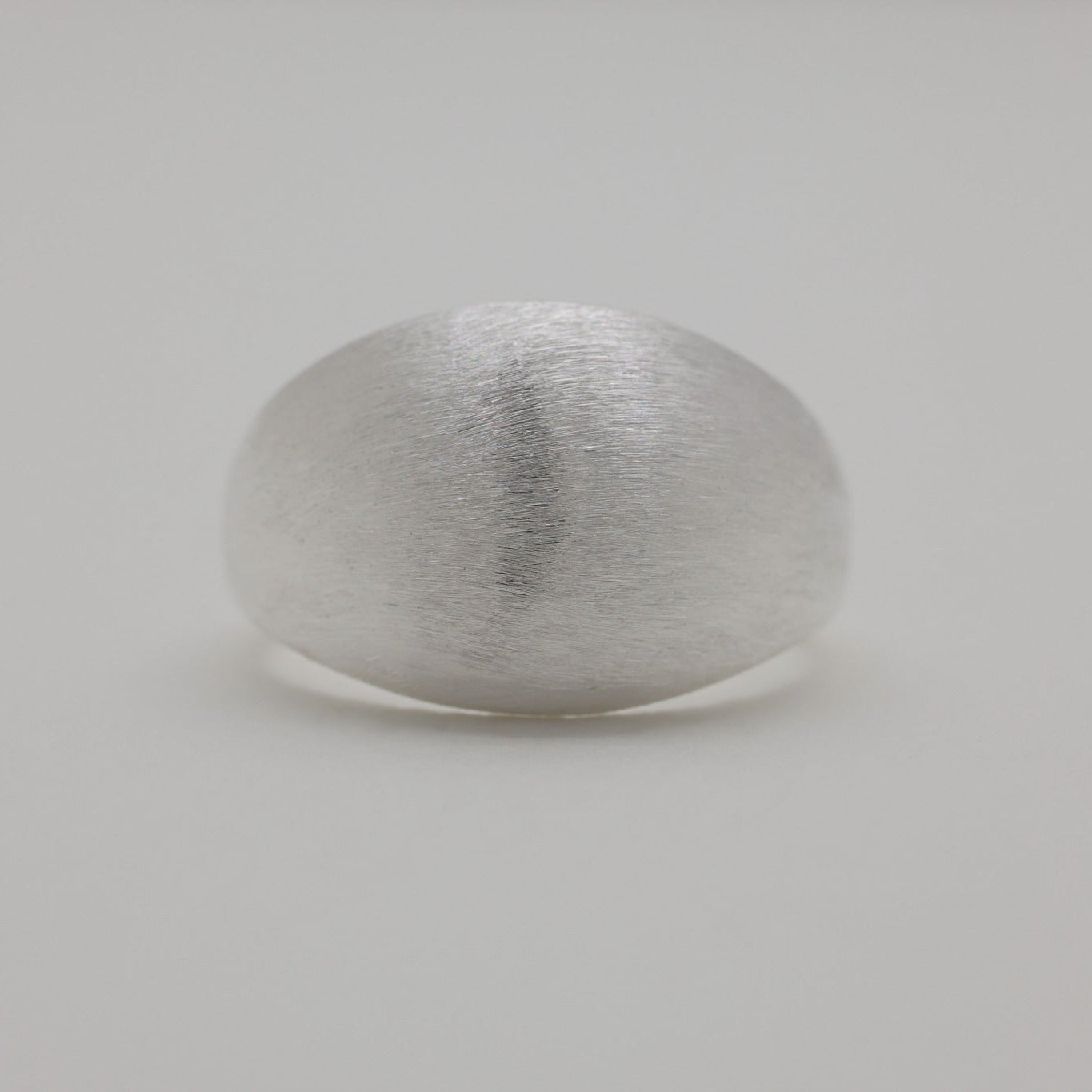 Close-up of brushed matte dome ring, showing curved form and texture