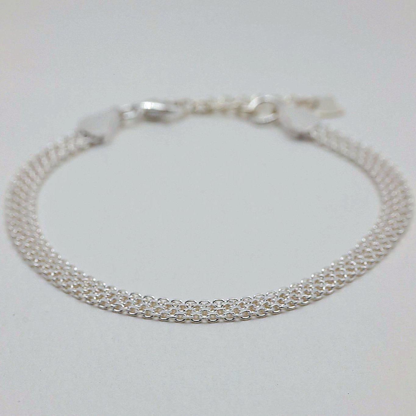 Angled view of the Marcelline Woven Bracelet highlighting its drape and shine