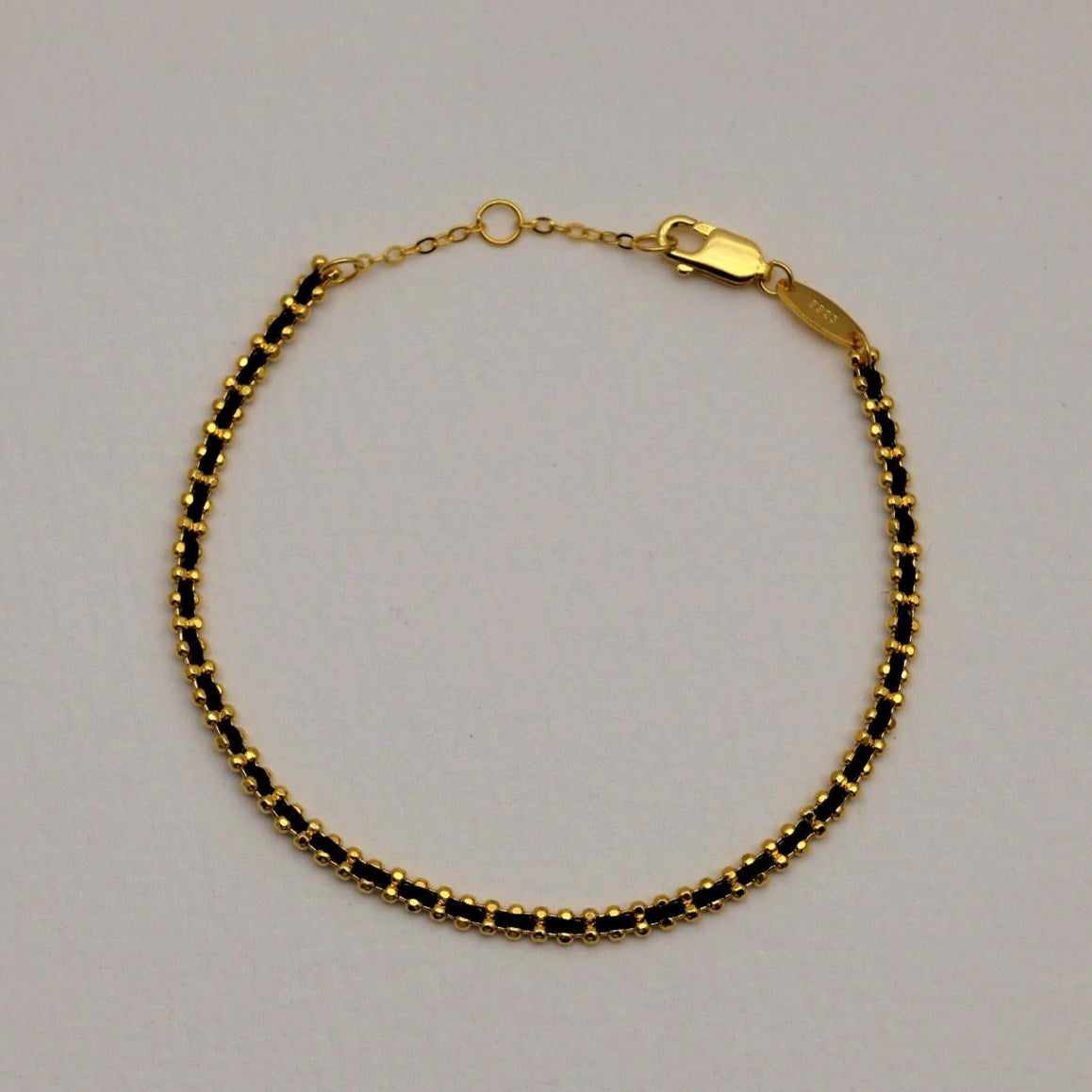 Full view of Agnès Bracelet laid in a circle with lobster clasp and extension.