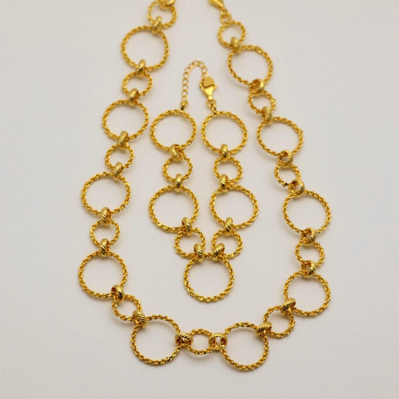 Ariette necklace and bracelet set, layered neatly on flat surface

