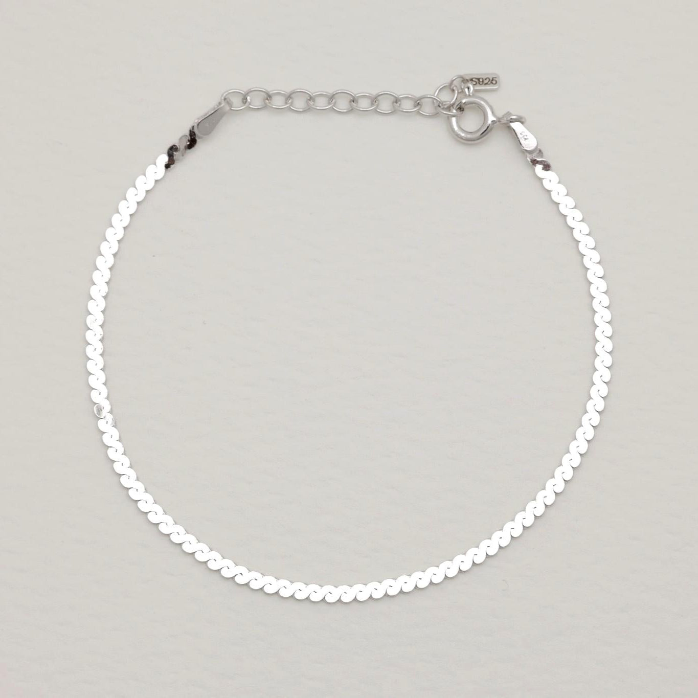 Full bracelet with clasp and extension chain in a soft arc.