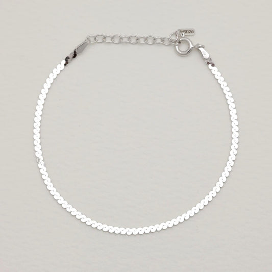 Full bracelet with clasp and extension chain in a soft arc.