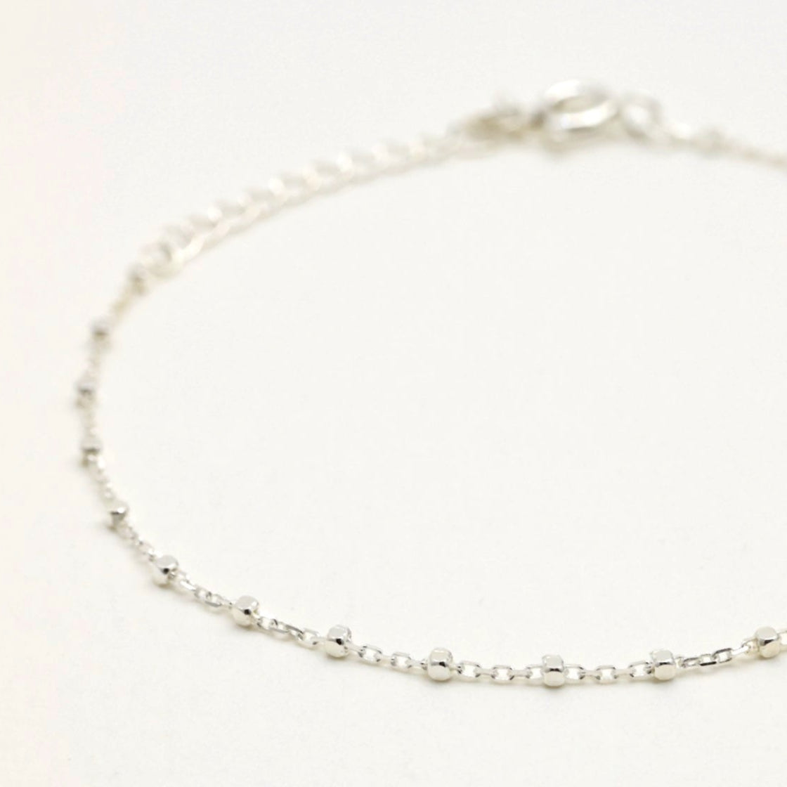 Side view showing the bracelet’s drape and spring clasp with extension.