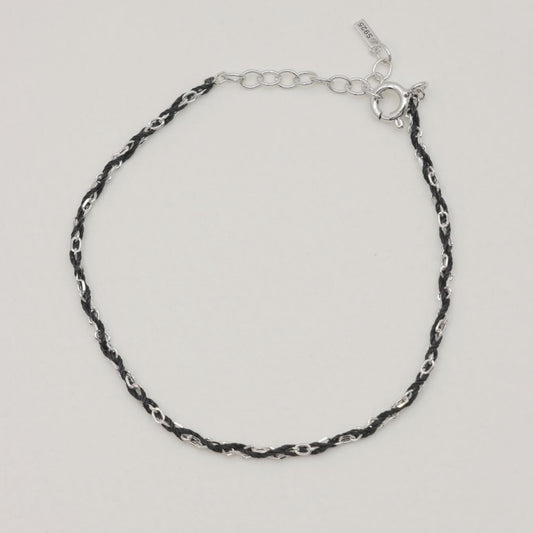 Sabine rope chain bracelet in sterling silver and black cord, full loop on soft background

