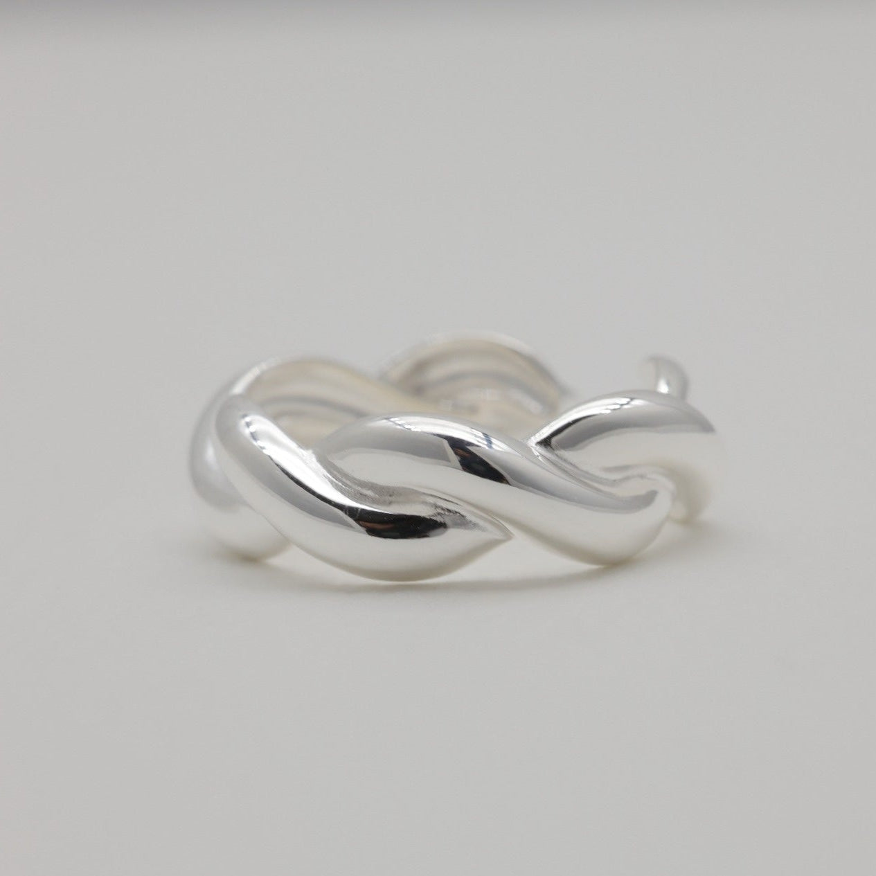 Close-up of sterling silver twist ring on neutral background